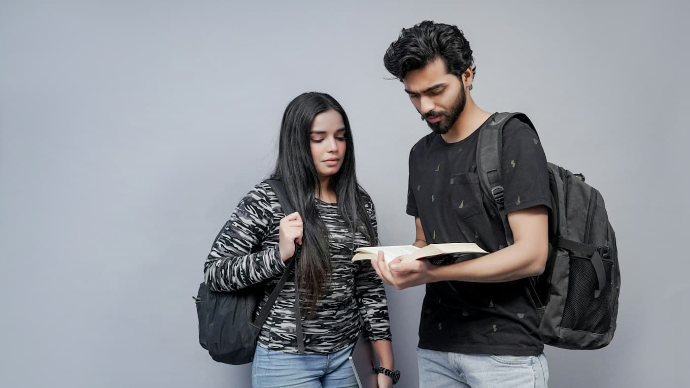 Two students reviewing a book together